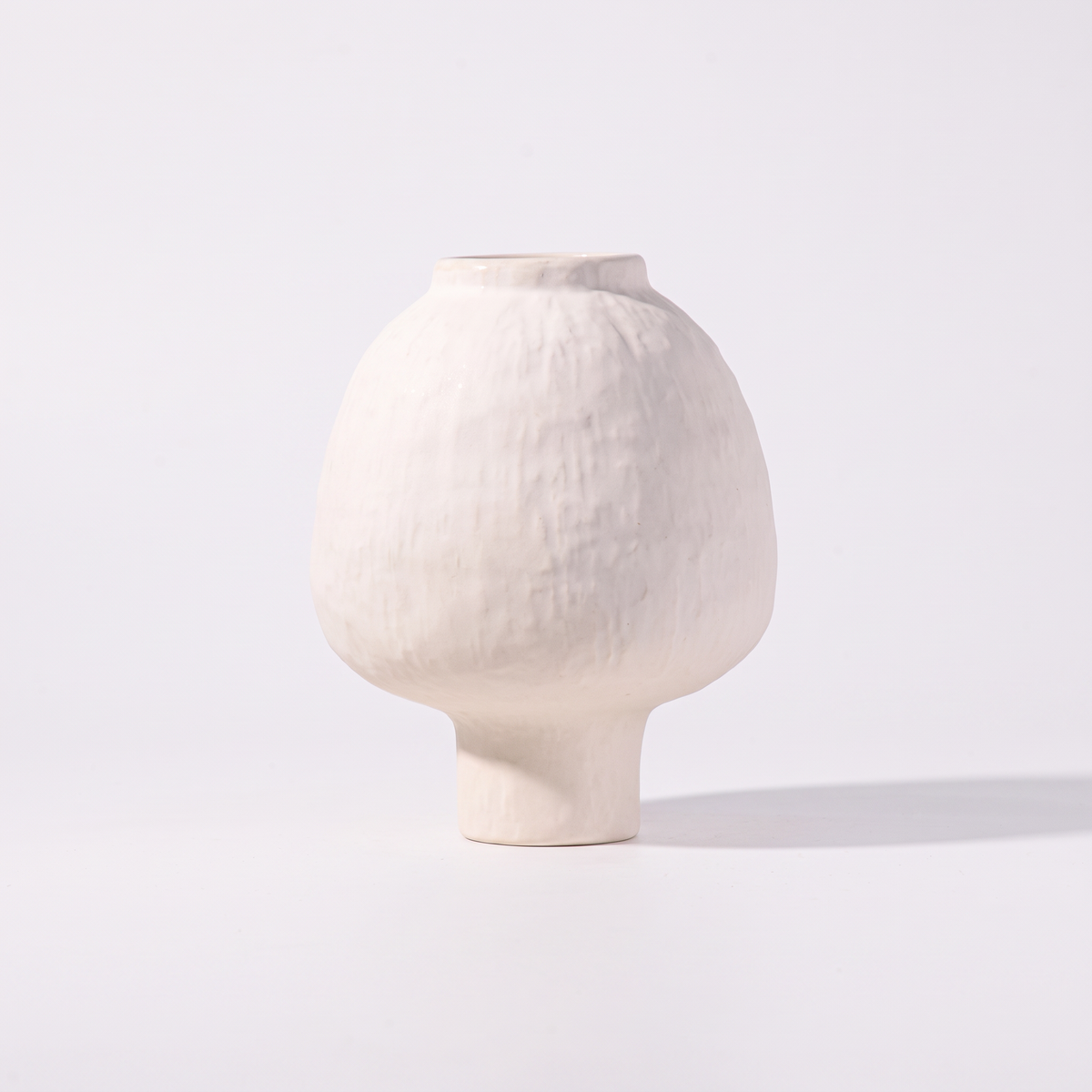 Handmade stoneware pedestal vase – Ivory, on a white background