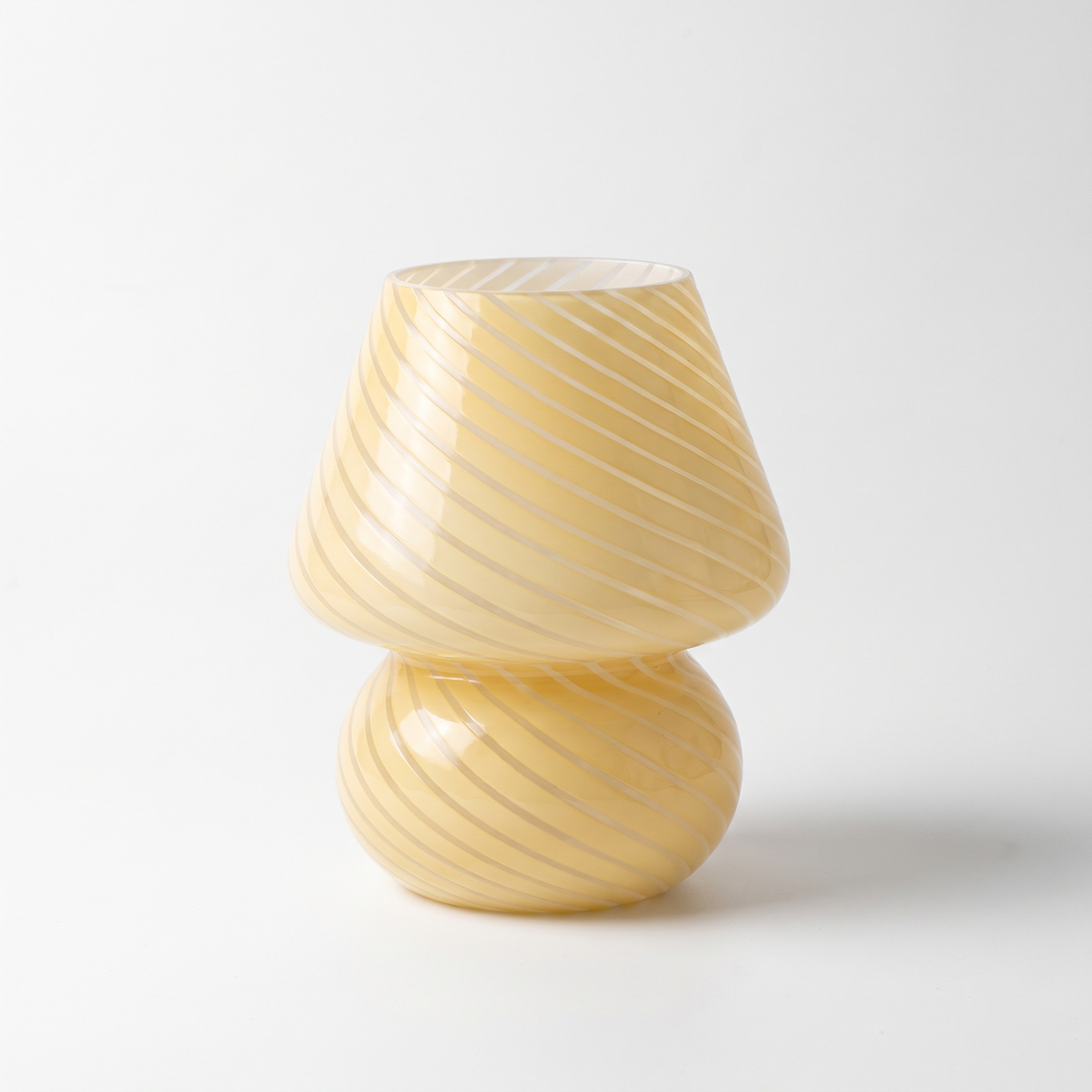 Butter yellow swirl glass mushroom lamp on a white background