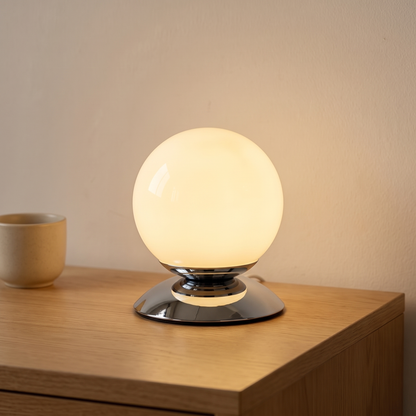 Cornsilk glass globe table lamp displayed in a warm modern interior