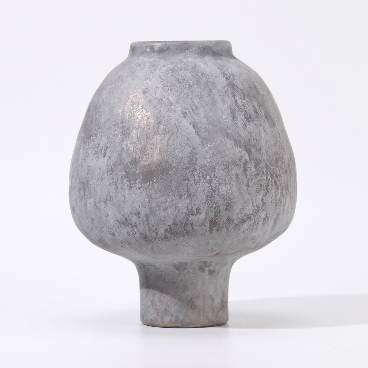 Handmade grey stoneware pedestal vase on a white background