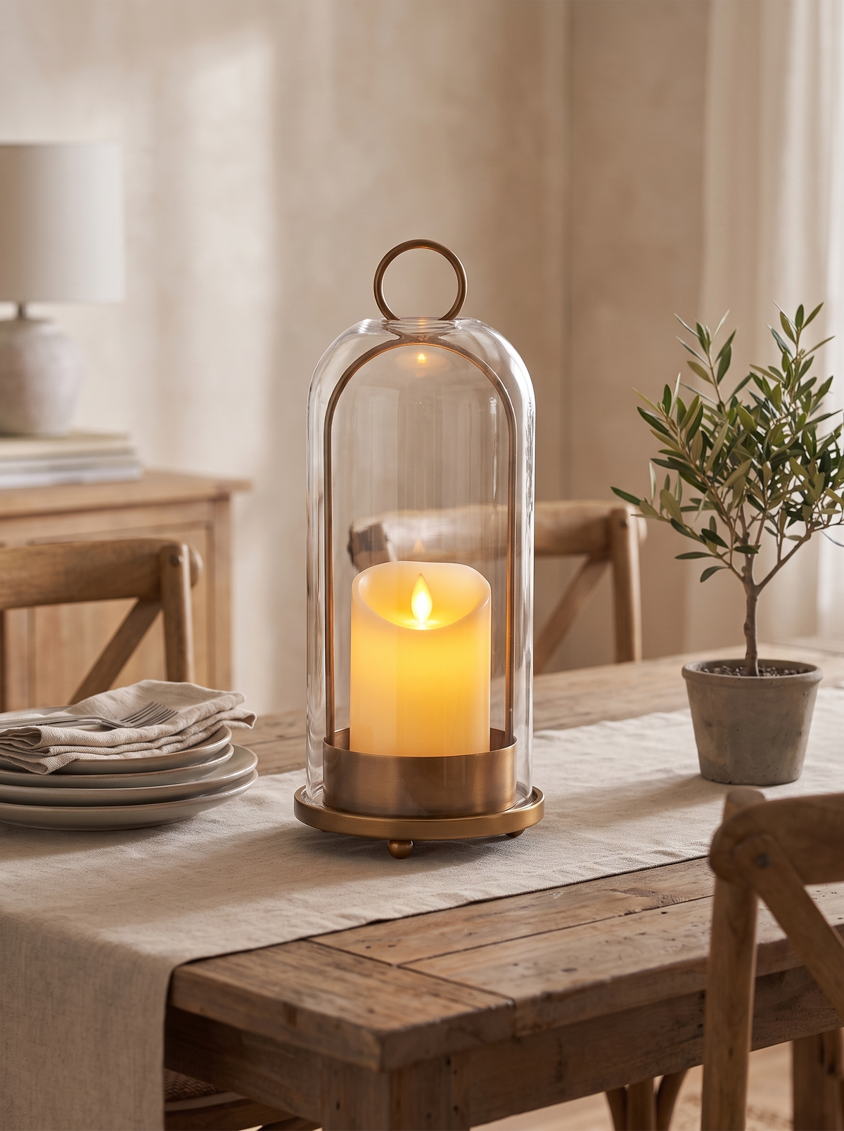 Glass dome sheltering a lit pillar candle