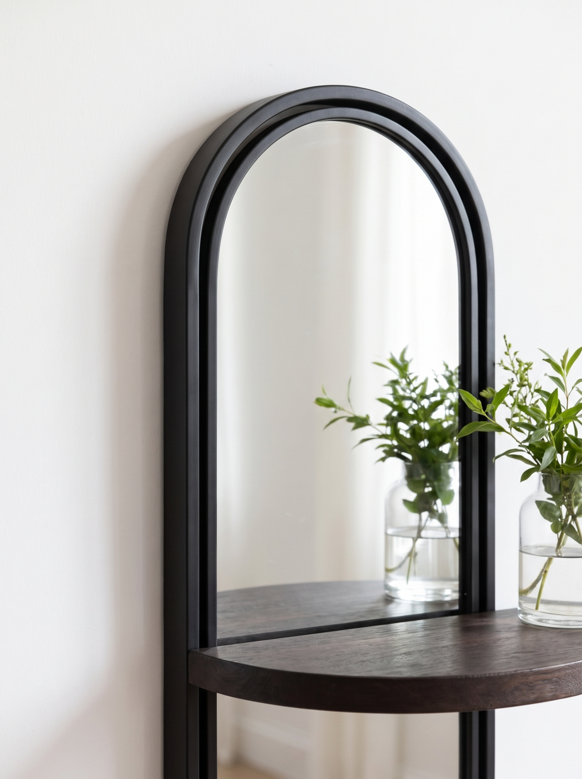 Close view of a slim black arched mirror frame